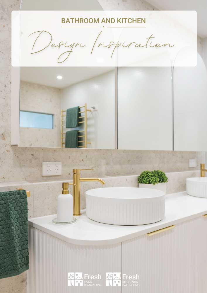 Modern bathroom vanity with a white ribbed cabinet, round sink, and gold faucet on a beige marble countertop; green towels on a wooden rack, and a signage banner reading 'Bathroom and Kitchen Design Inspiration'.