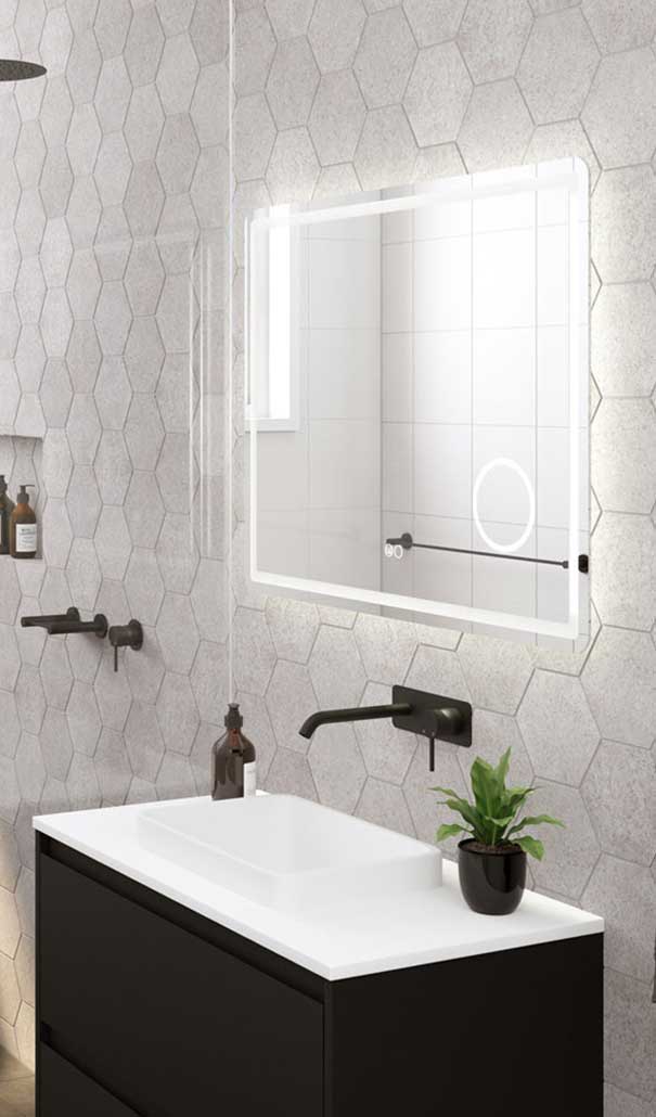 Modern bathroom with backlit rectangular mirror above a white sink and black vanity, hexagonal gray wall tiles, and a small plant.